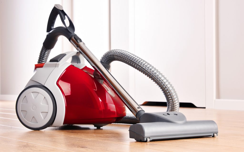 Canister vacuum cleaner for home use on the floor.
